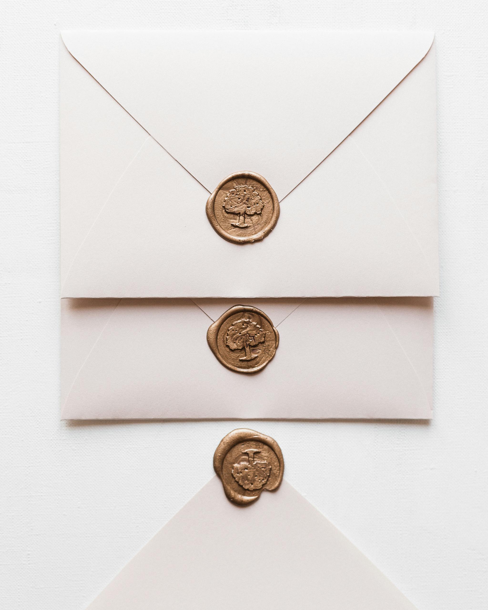 Three elegant envelopes featuring decorative wax seals on a white background.